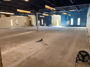 Workers preparing a large commercial concrete floor for finishing at a Desired Finishes project in Ann Arbor, MI