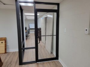 A new commercial glass and metal door installation in an office setting by Keeler Construction Group Inc. in Blue Island, IL.