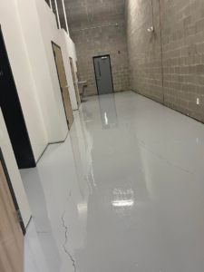 A newly applied grey epoxy floor coating in a commercial hallway by Quality Painting of Raleigh in Raleigh, NC.