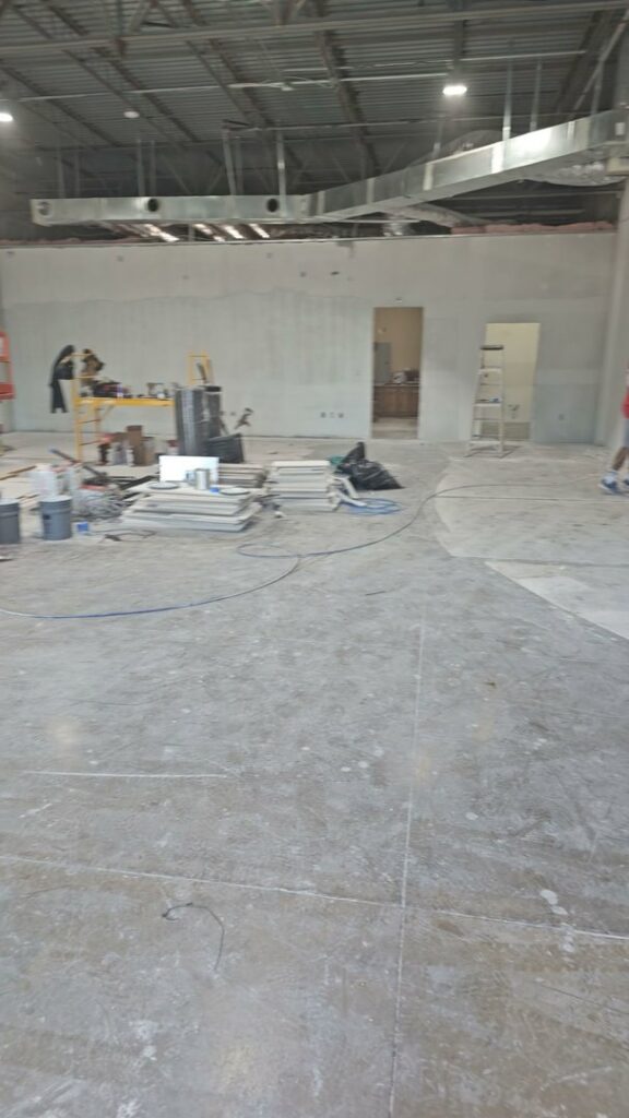 A large commercial interior space under construction with an exposed ceiling and concrete floor by M.M. Remodelers in Resaca, GA.