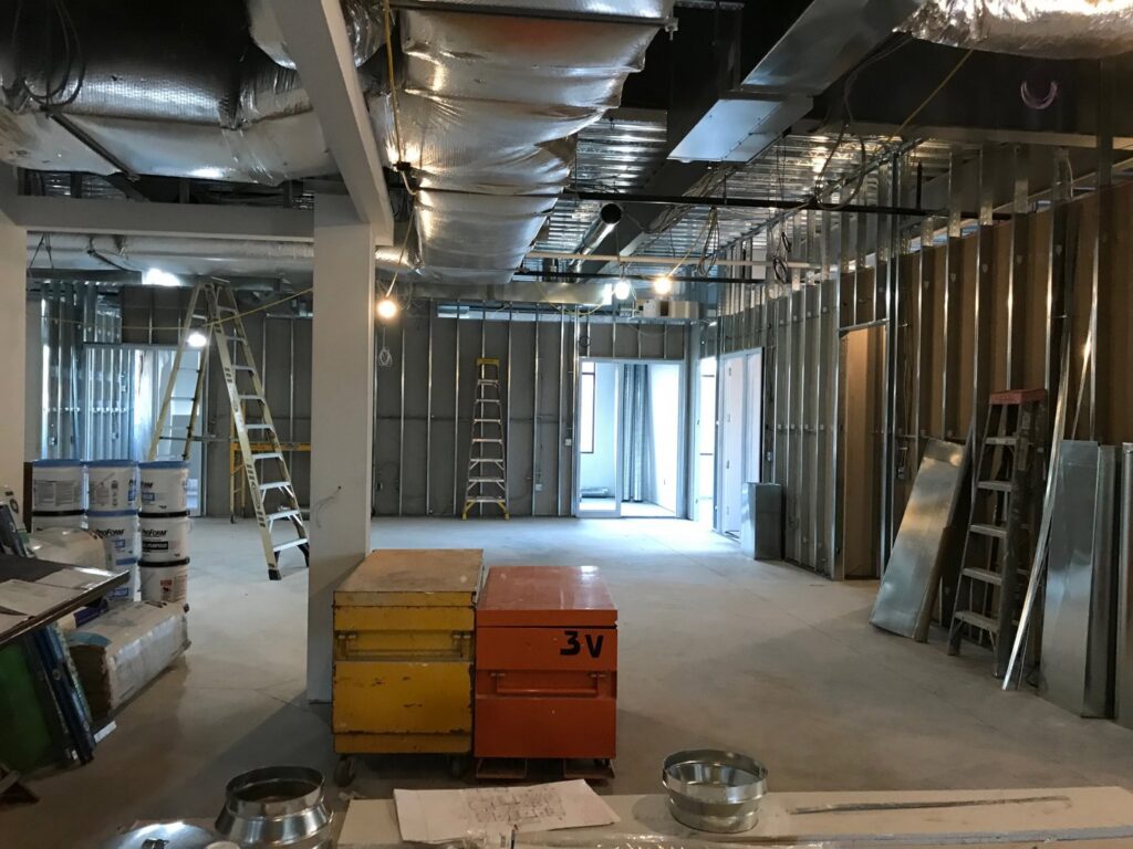 A commercial interior construction site with metal framing and exposed ceiling by Pharos Contracting Company Inc. in Newark, NJ