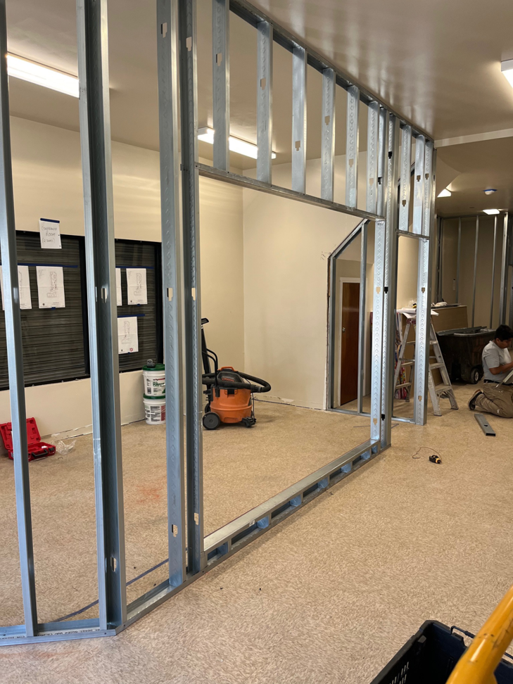 Interior commercial space undergoing renovation with metal stud wall framing by Pharos Contracting Company Inc. in Newark, NJ