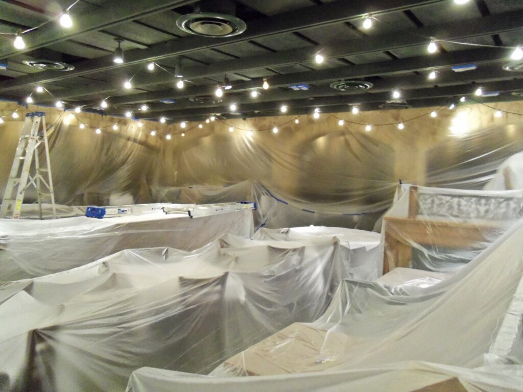 Commercial interior room fully prepped with plastic sheeting for painting by Vico Painting Contractors in Hialeah, FL