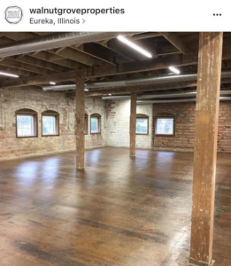 A spacious commercial interior renovation with exposed brick walls and wooden columns by Failsafe Electric, Inc. in Metamora, IL.