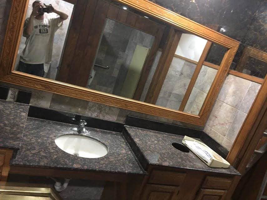 An interior commercial space with wood paneling and mirrors, set up for renovation by Landon and David handyman in Wichita, KS.