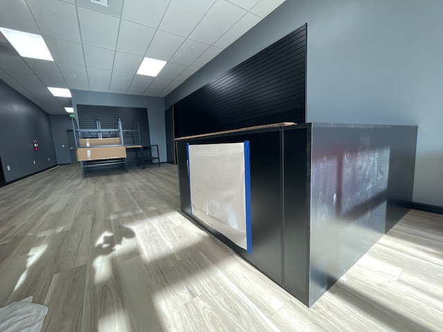 An ongoing commercial interior renovation project with new slat walls and a partially built counter by Summit Crest Construction, LLC in Yakima, WA.