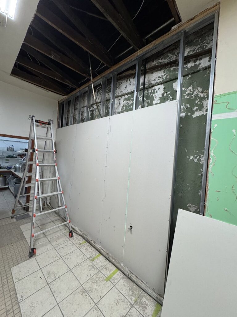 A commercial kitchen with a stainless steel exhaust hood and cooking equipment installed by ProKitchen Solutions in Russiaville, IN