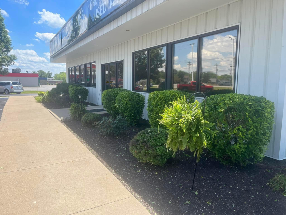 Neatly trimmed bushes and landscaping maintenance at a commercial building by E&K Property Preservation in Lake, MI.