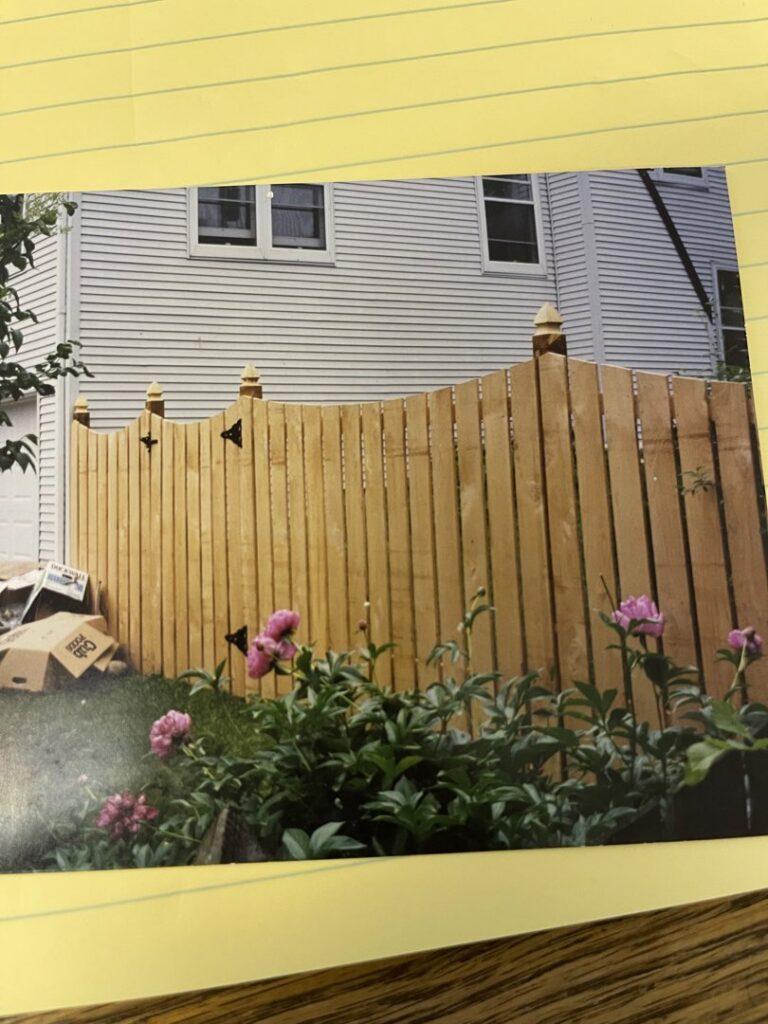 Workers installing a black metal fence around a commercial building by Security Fence & Construction Inc in Minneapolis, MN.