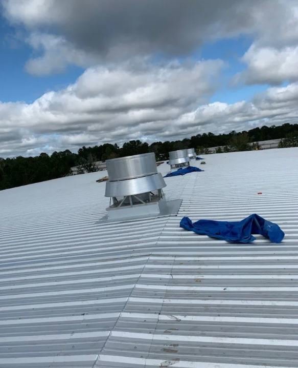 New commercial metal roof installation with ventilation systems by Total Improvements LLC, a general contractor in San Antonio, TX.