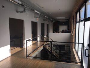 A commercial office interior build-out with exposed ductwork and modern stairs by 3F Construction in Chicago, IL.