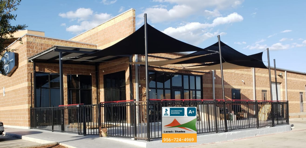 Black shade sails installed over a commercial patio area by Laredo Shades, a general contractor in Laredo, TX.