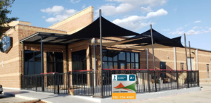 Black shade sails installed over a commercial patio area by Laredo Shades, a general contractor in Laredo, TX.