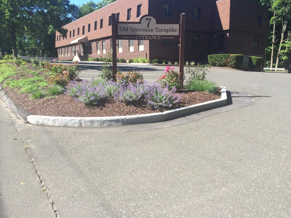 A well-maintained commercial property entrance with a landscaped island by Discovery Enterprises LLC in Danbury, CT.