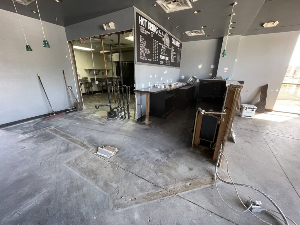 Interior of a commercial space undergoing renovation with removed fixtures and debris, showing junk removal by HAVOC Demolition in Scottsdale, AZ.