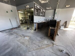 Interior of a commercial space undergoing renovation with removed fixtures and debris, showing junk removal by HAVOC Demolition in Scottsdale, AZ.