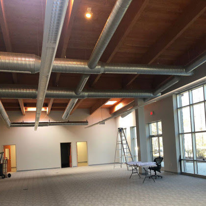 An ongoing commercial renovation project featuring exposed ductwork and a wooden ceiling, managed by Falls Contracting, LLC in Raleigh, NC.