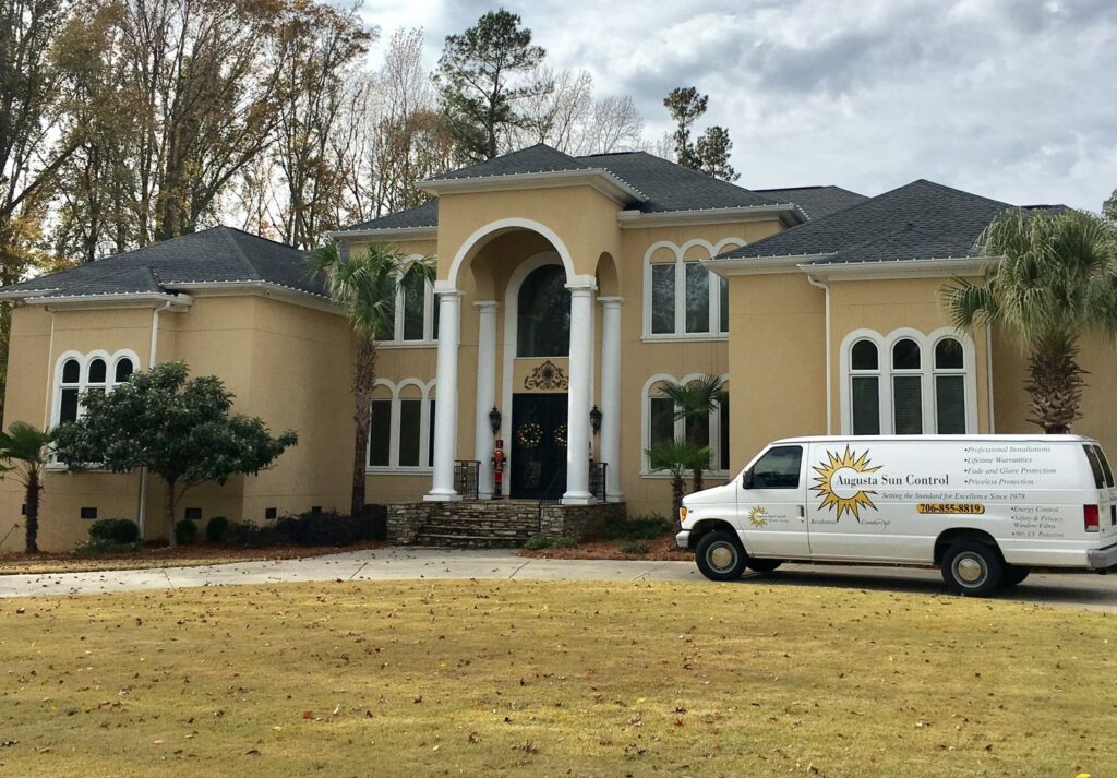 Augusta Sun & UV Control van parked in front of a large residential property for window tinting services in Augusta, GA.