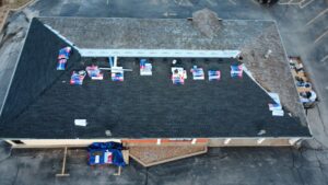 An aerial view of a commercial building roof with new shingles being installed by Element Enterprises in Kansas City, MO.