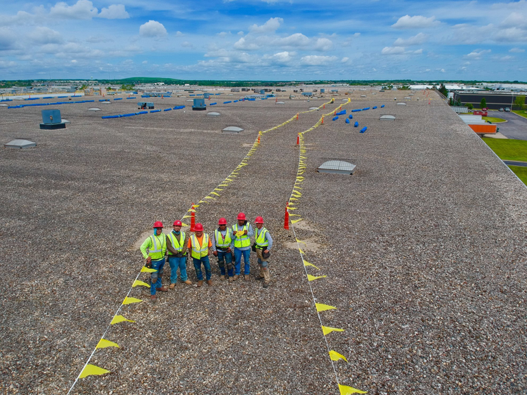 A commercial roofing crew on a large flat roof project by Active Roofing Company in Chicago, IL