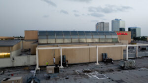 Commercial rooftop maintenance with workers on a ladder by Painting Professionals, Inc. in Houston, TX
