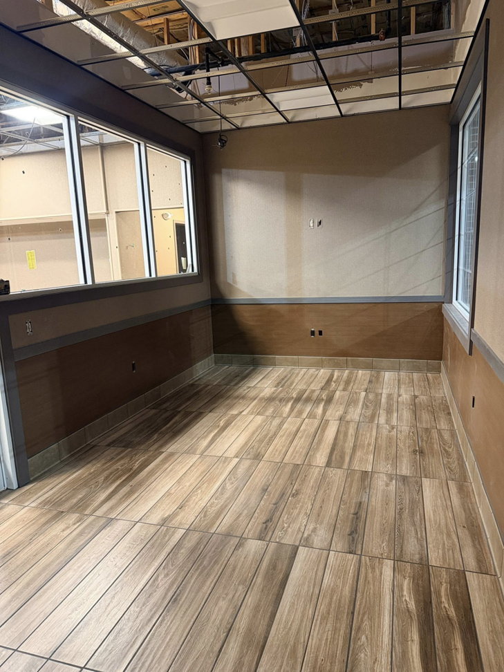 A newly installed wood-look tile floor in a commercial room by P.G.R Construction,Inc in Rehoboth, MA.