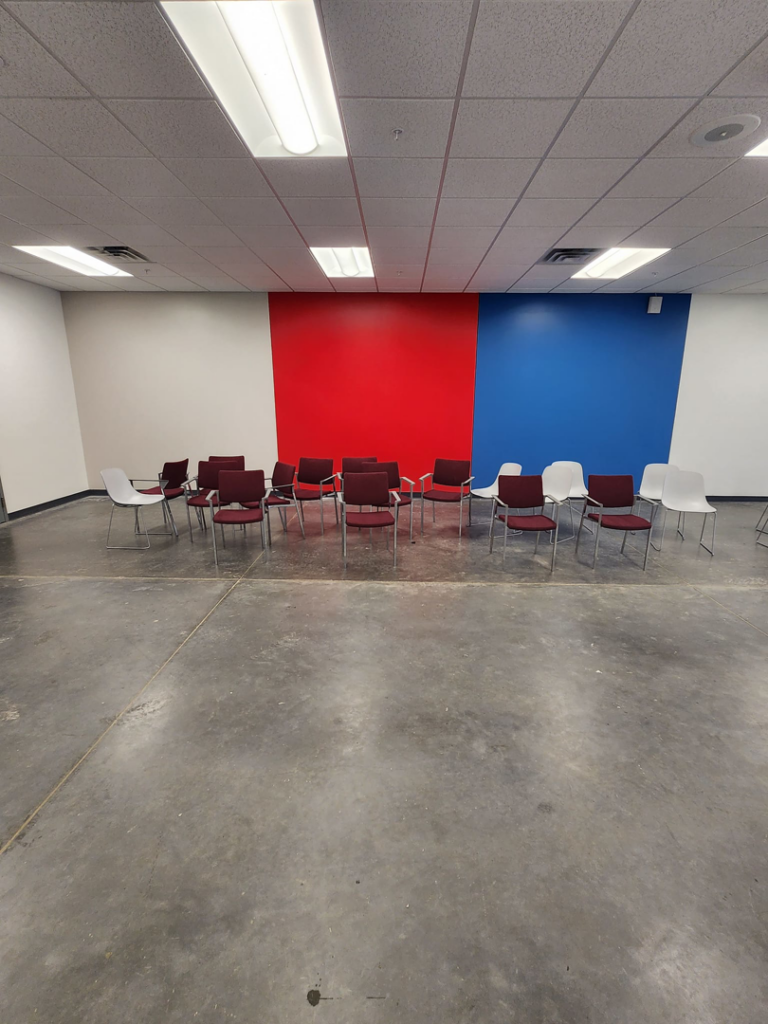 A commercial room with a freshly painted white, red, and blue accent wall, completed by Reshaud Renovation LLC in Richmond, VA.