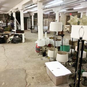 A large commercial space filled with lamps and various items, indicating a cleanout project for Music City Removal in Nashville, TN.