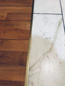 A commercial space with a stage and tiled floor, undergoing cleanup with a shop vac by Landon and David handyman in Wichita, KS.