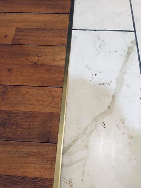 A commercial space with a stage and tiled floor, undergoing cleanup with a shop vac by Landon and David handyman in Wichita, KS.