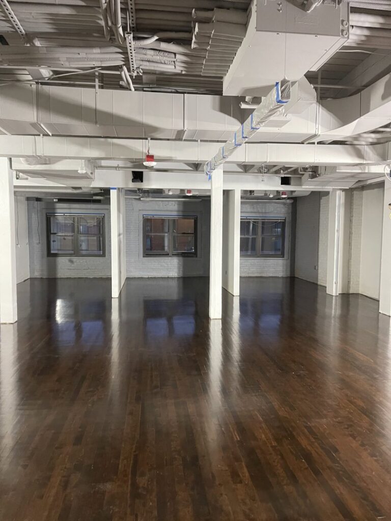 Commercial space with dark hardwood floors and exposed ceiling by Diamond Flooring LLC in Boston, MA