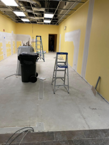 Commercial space renovation with yellow walls and exposed ceiling grid by Strom Contracting LLC in Crystal Lake, IL.