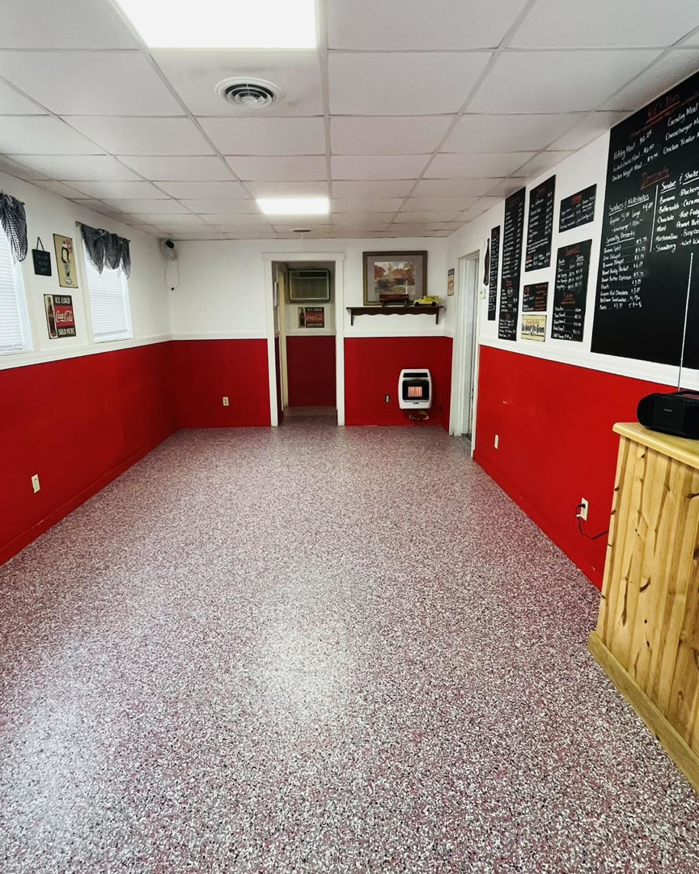 A completed commercial space renovation with red and white walls and a new speckled floor by A 2 Z Home Services - Fairmont WV.