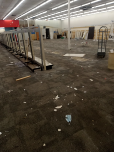 An empty commercial store space with scattered debris and dismantled fixtures after a cleanout by Cox Junk & Debris Removal in Buffalo, NY.