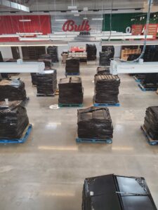 Commercial store fixtures wrapped in plastic on pallets for removal by Jugganott Recycling, LLC in Orlando, FL.