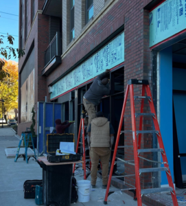 Workers installing a commercial storefront window frame for Capital Construction & Contracting LLC in Raleigh, NC