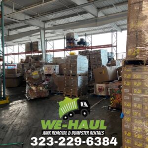 A commercial warehouse with stacked boxes and junk on pallets, indicating a commercial junk removal service by We-Haul Junk Removal in Long Beach, CA