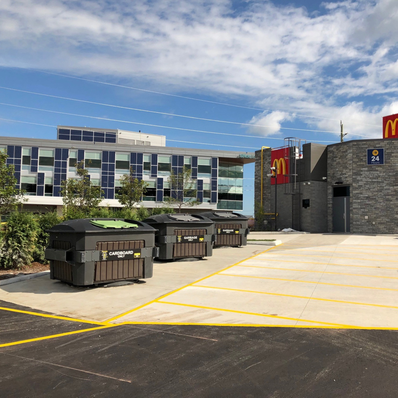 Commercial waste and recycling bins outside a McDonald's serviced by Binova Group in Knoxville, TN.