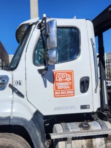 The side of a Community Disposal truck displaying the business logo and contact information in Jacksonville, FL.