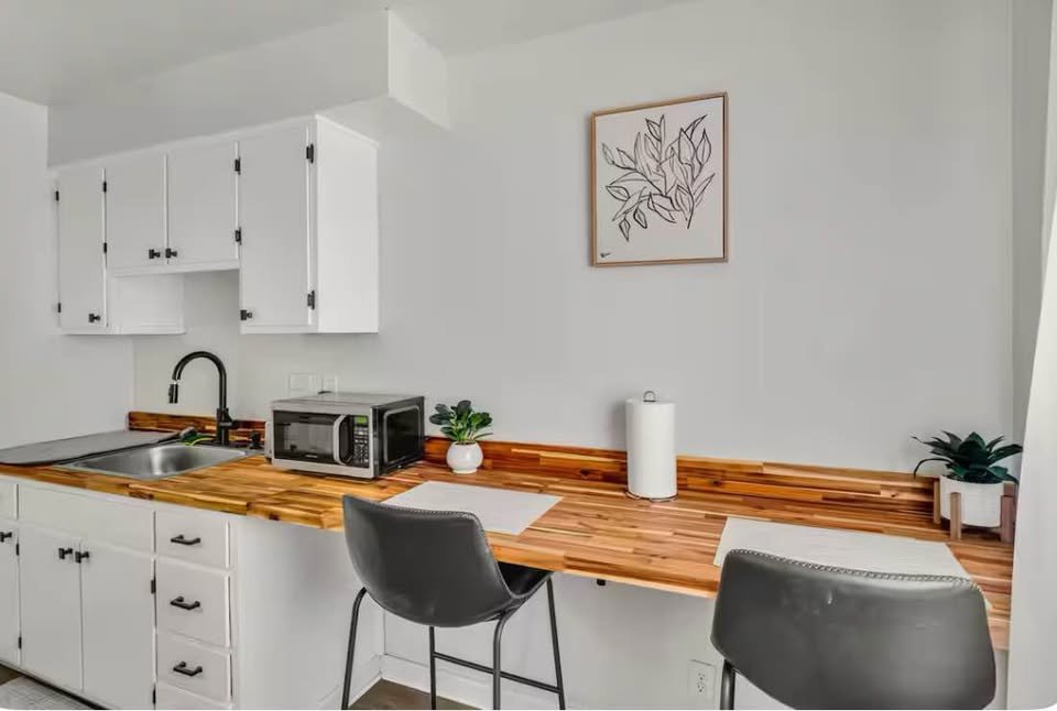 A compact kitchenette installation with wood countertops and white cabinets by Imperial Access Contracting in Evansville, IN.