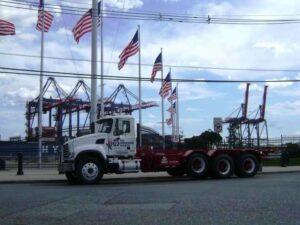 A branded semi-truck from All American Alloys and Recycling Inc. parked near a port in Elizabeth, NJ.