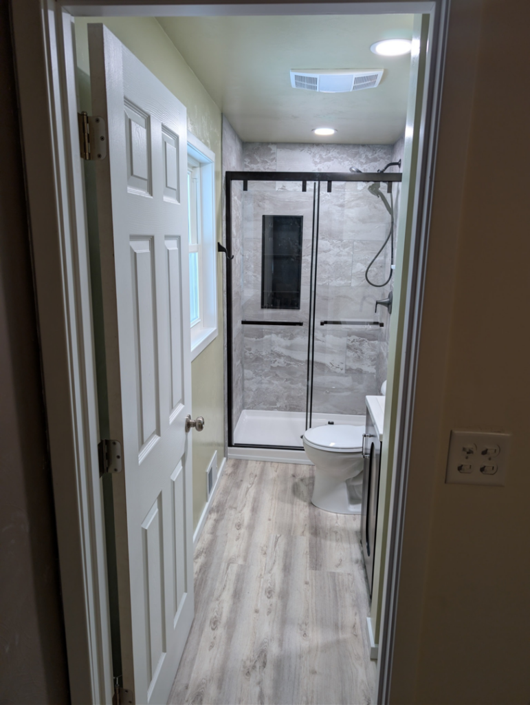 A complete bathroom renovation showcasing new shower, toilet, and vanity by A&A Property Renovations LLC in Green Bay, WI.