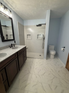A complete bathroom renovation with a double vanity, toilet, and walk-in shower by Craft Tile Co in Springfield, MO.
