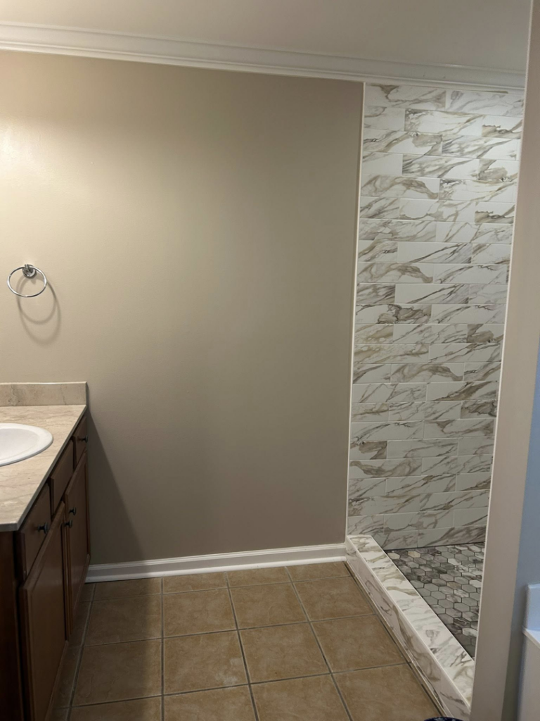 A complete bathroom renovation featuring a new tiled shower and fresh paint by Ingram Painting and Renovation in Birmingham, AL.