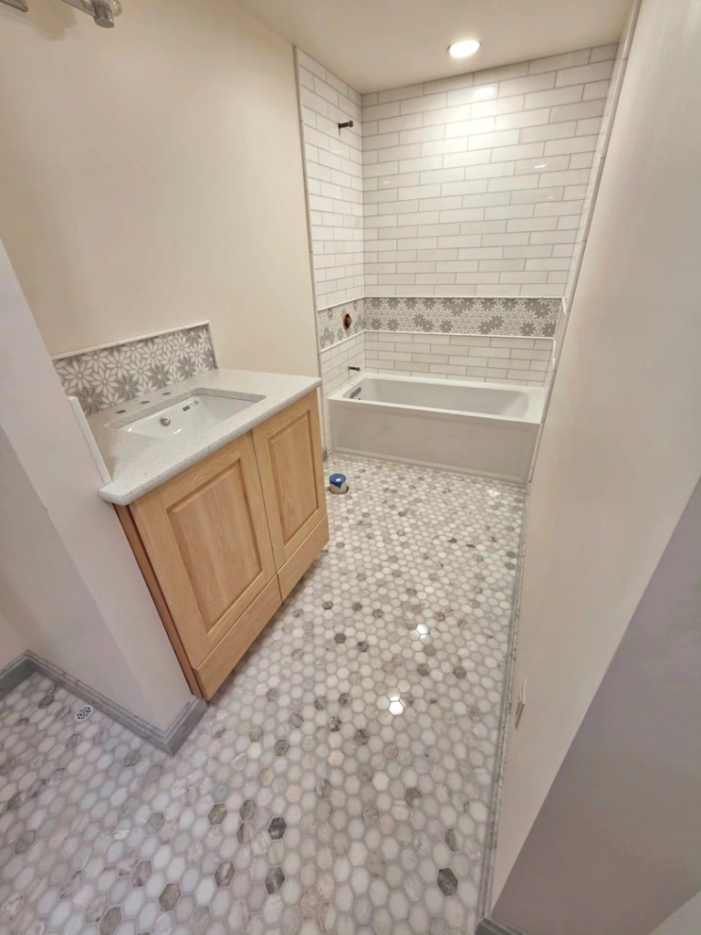 A complete bathroom renovation featuring new tiling and vanity by Tyler the Tiler in Jefferson, WI.