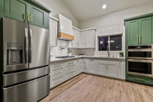 A complete kitchen remodel featuring green and light gray cabinets, new appliances, and wood-look flooring by Innovative Design & Construction in Linwood, KS.