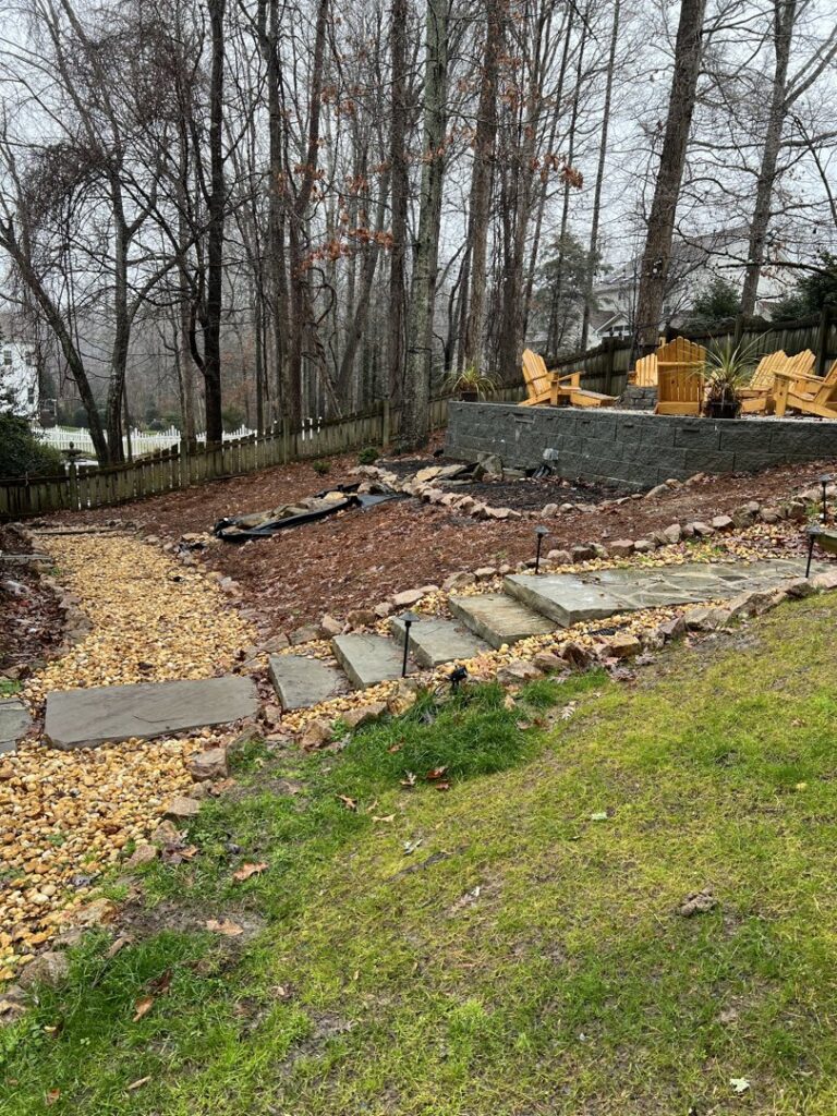 A completed backyard drainage and landscaping project with gravel paths and stone steps by Drip Dry Drainage in Cramerton, NC.