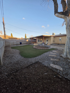 A newly installed artificial turf and gravel backyard by Luis handyman service in Albuquerque, NM