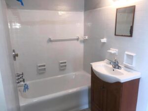 A completed bathroom refinishing project with a white tub and tiled walls by Phillys Finest Tub & Tile Refinishing in Philadelphia, PA