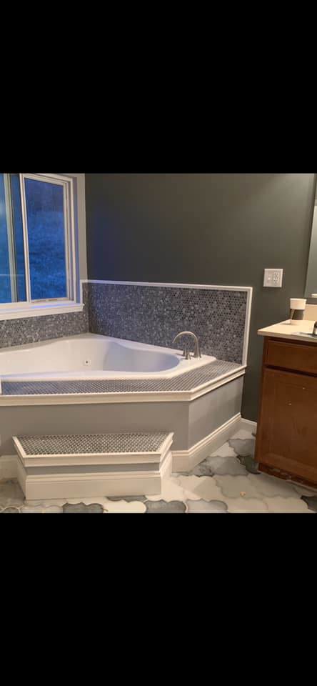 A beautifully completed bathroom remodel featuring a corner bathtub with elegant tile work by Berling Remodeling llc in Highland Heights, KY.